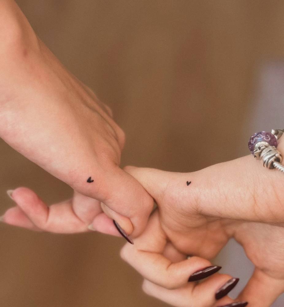 Matching minimalistic heart tattoo for couple.