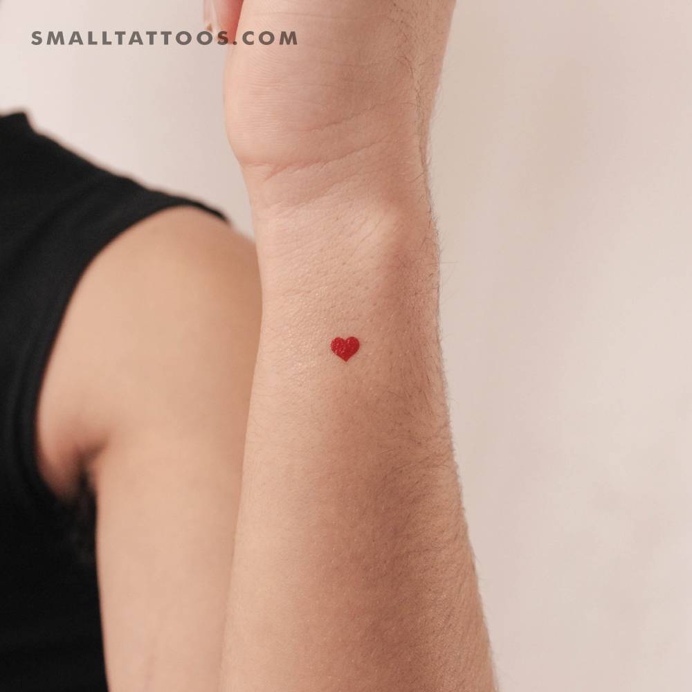 Small minimalistic red heart temporary tattoo done on the wrist.