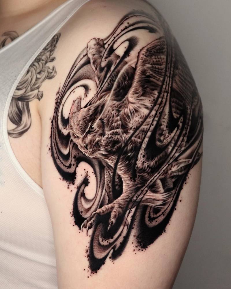 Owl tattoo done in abstract style located on the shoulder.
