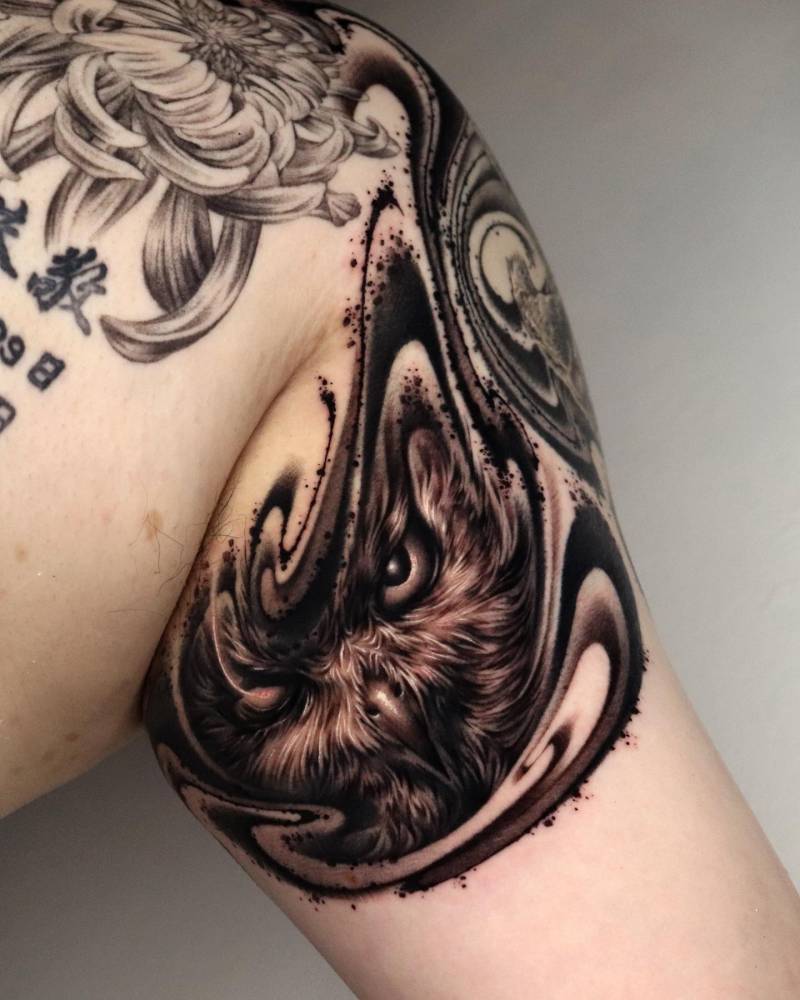 Owl portrait tattoo in abstract style located on the inner arm.