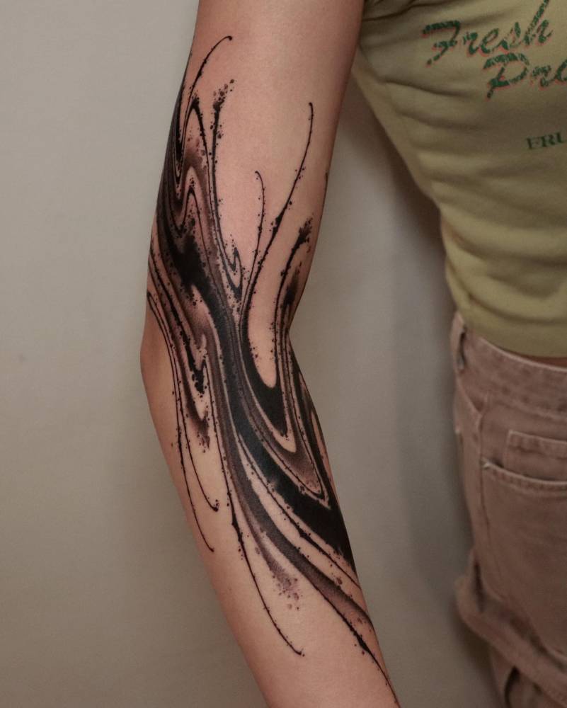 Abstract design tattooed on the arm, done in blackwork style.