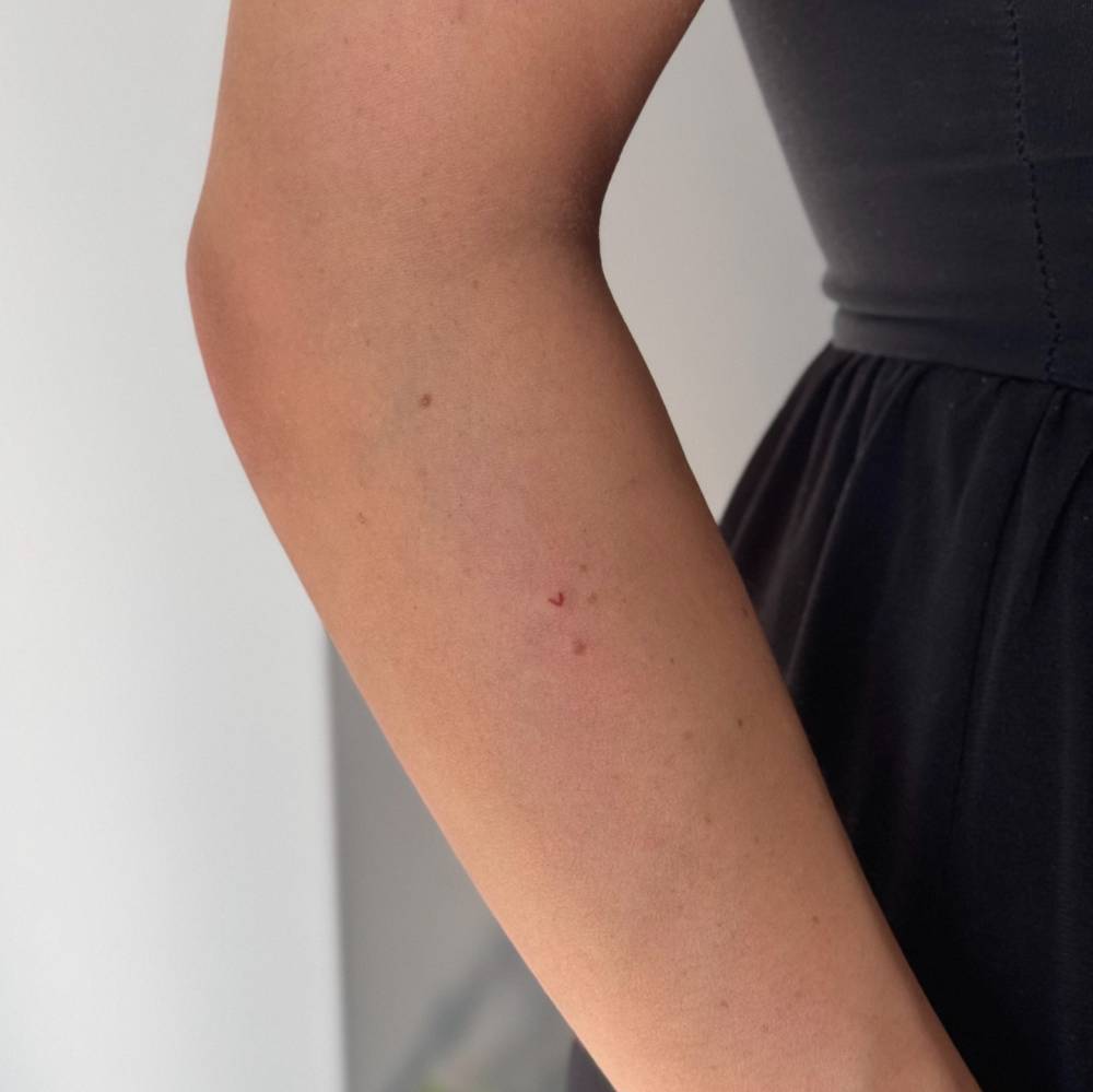 Tiny minimalistic freckle heart tattoo located on the forearm.
