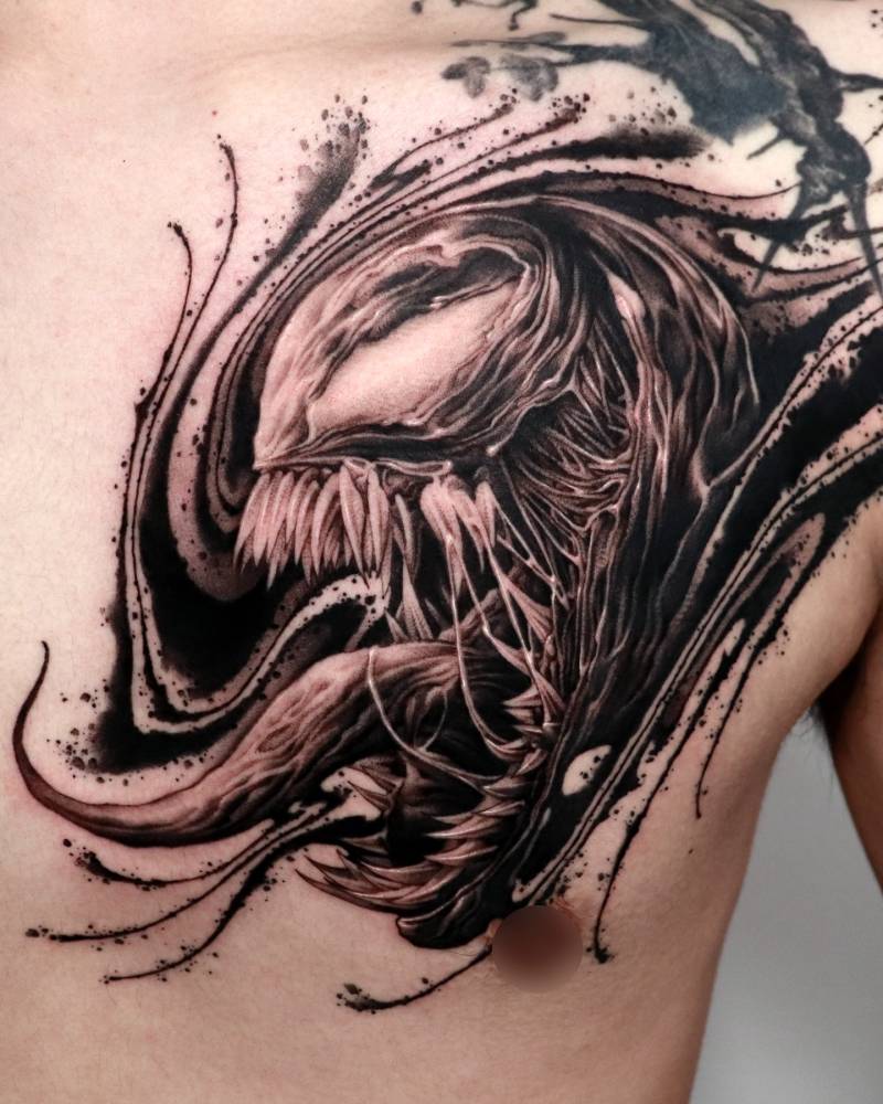 Venom portrait tattoo in blackwork style located on the chest.