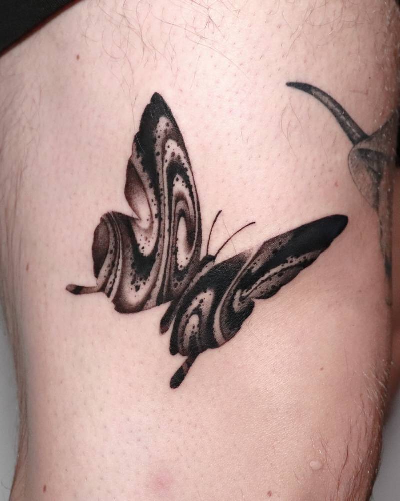 Blackwork style abstract butterfly tattoo done on the thigh.