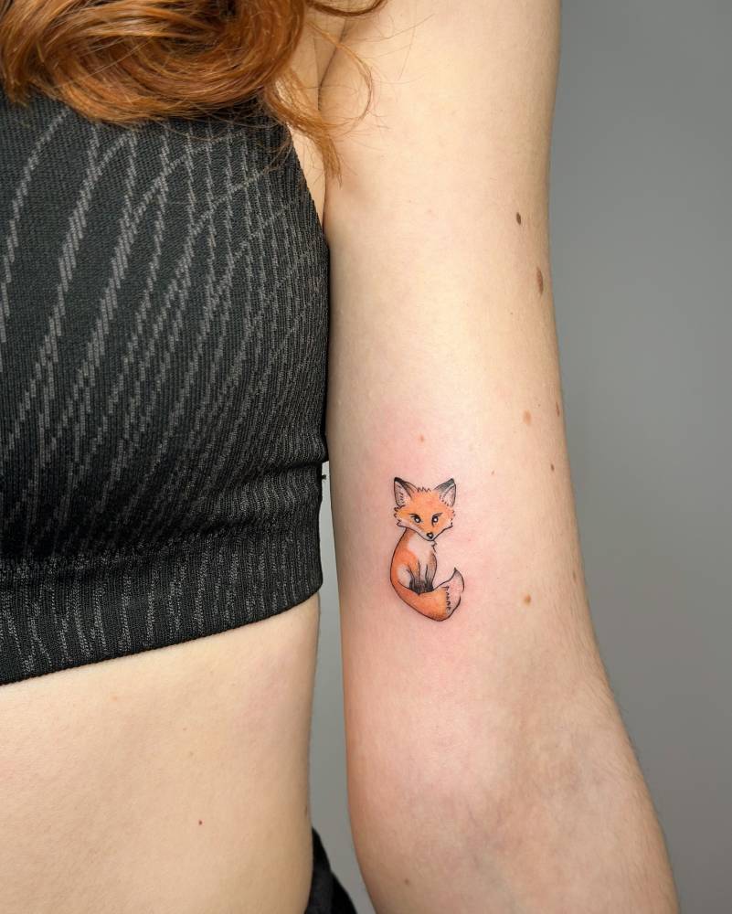 Little fox tattoo in illustrative style located on the inner arm.