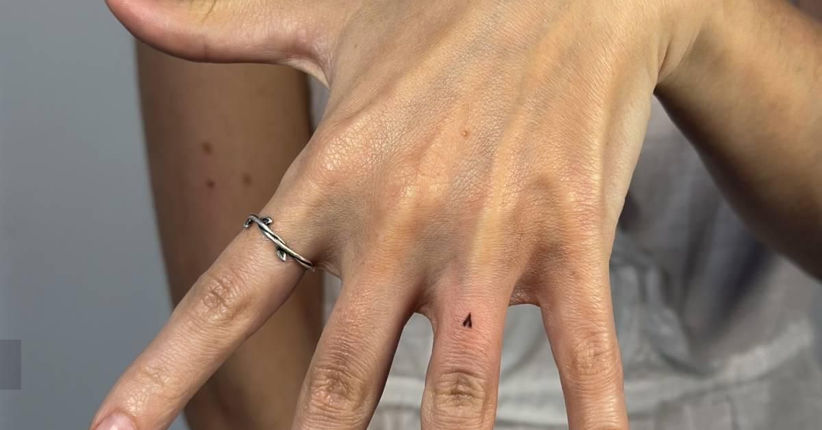 Tiny minimalistic heart tattoo located on the finger.