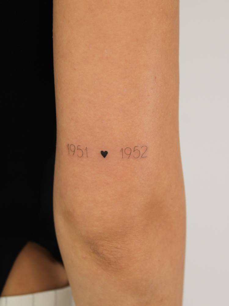 "1951" and "1952" lettering tattoo located on the tricep.