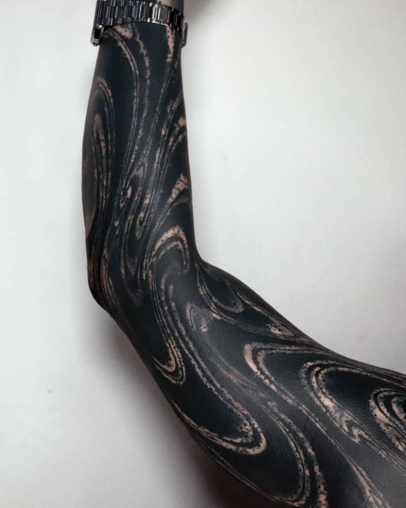 Abstract sleeve tattoo in blackwork style.