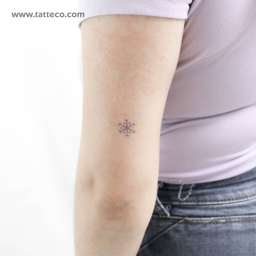 Minimalistic snowflake temporary tattoo located on the tricep.