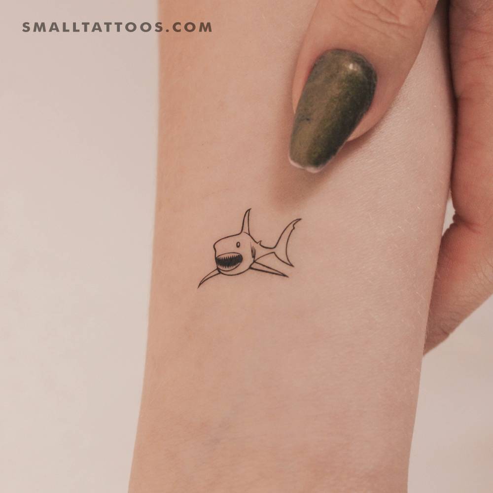 Little shark temporary tattoo located on the wrist.