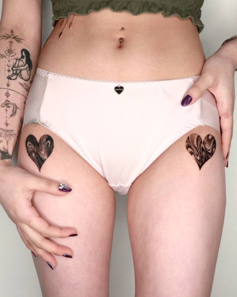 Abstract style individual matching hearts tattooed on the hips.