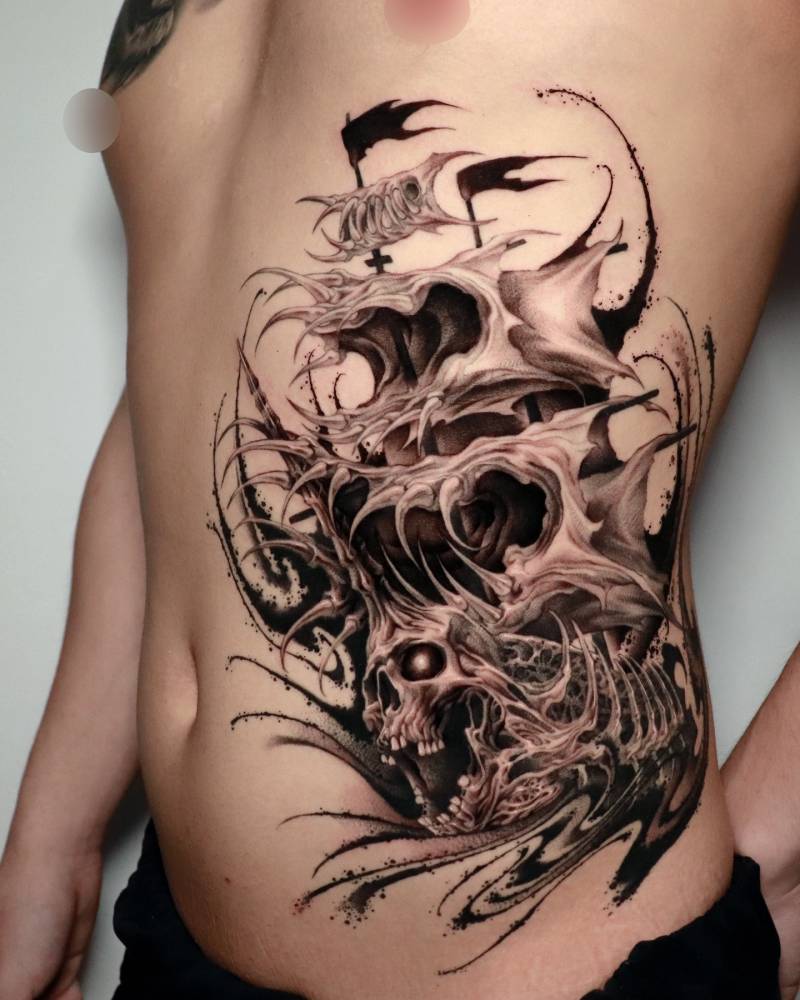 Abstract sailing ship and skull tattoo located on the rib.