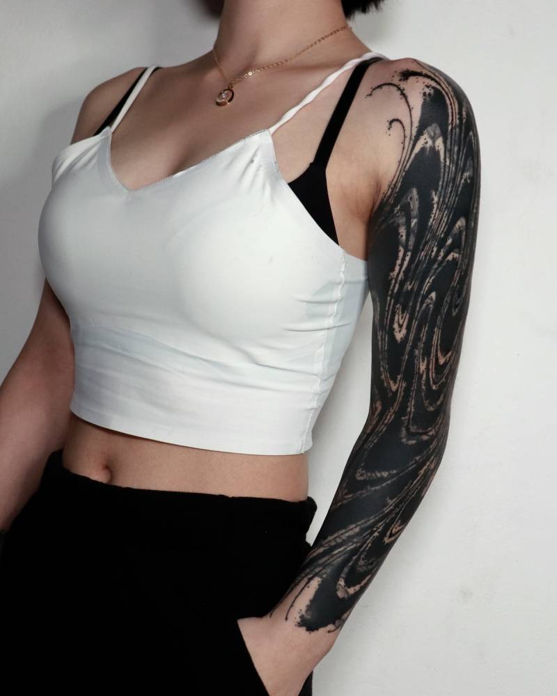 Old tattoo cover-up sleeve in blackwork style.