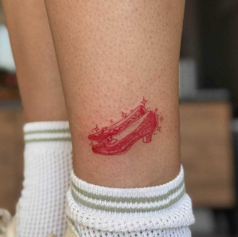 Ruby slippers tattoo in red ink located on the ankle.