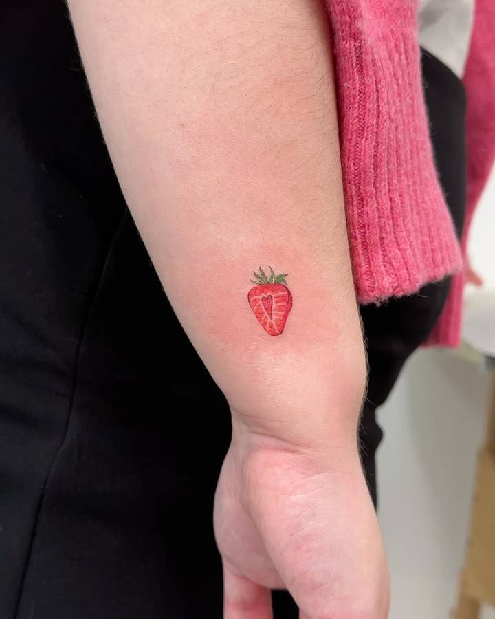Illustrative style strawberry tattoo located on the wrist.