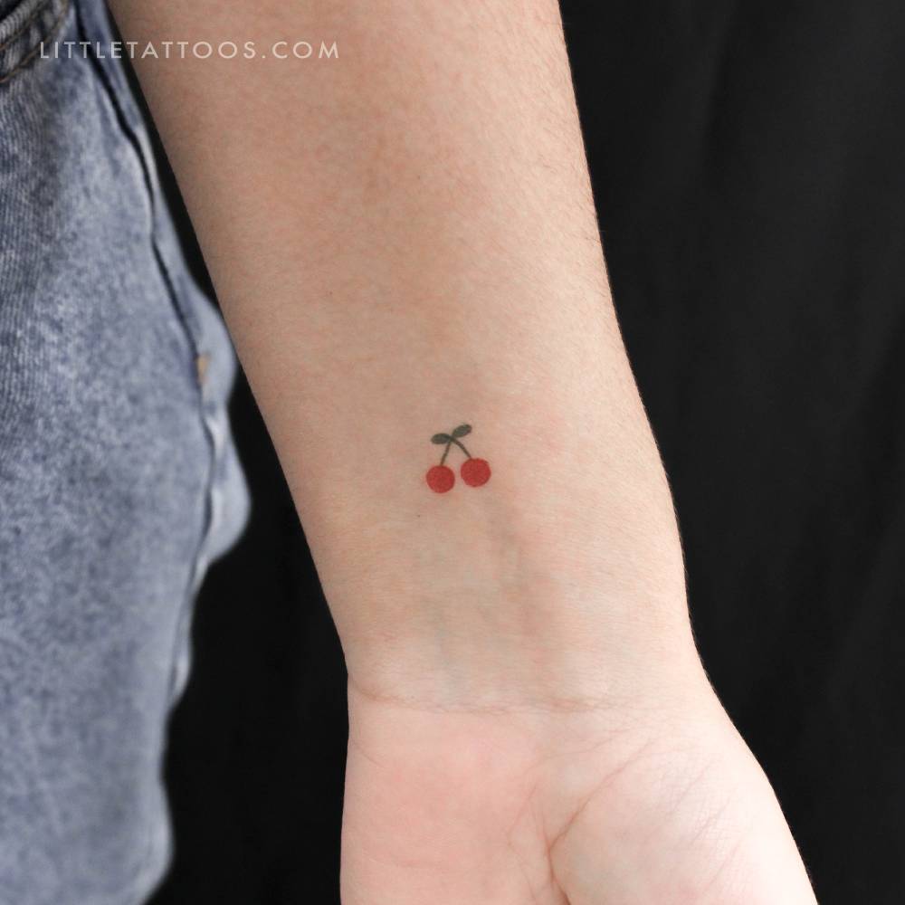 Tiny minimalistic cherry temporary tattoo located on the wrist.