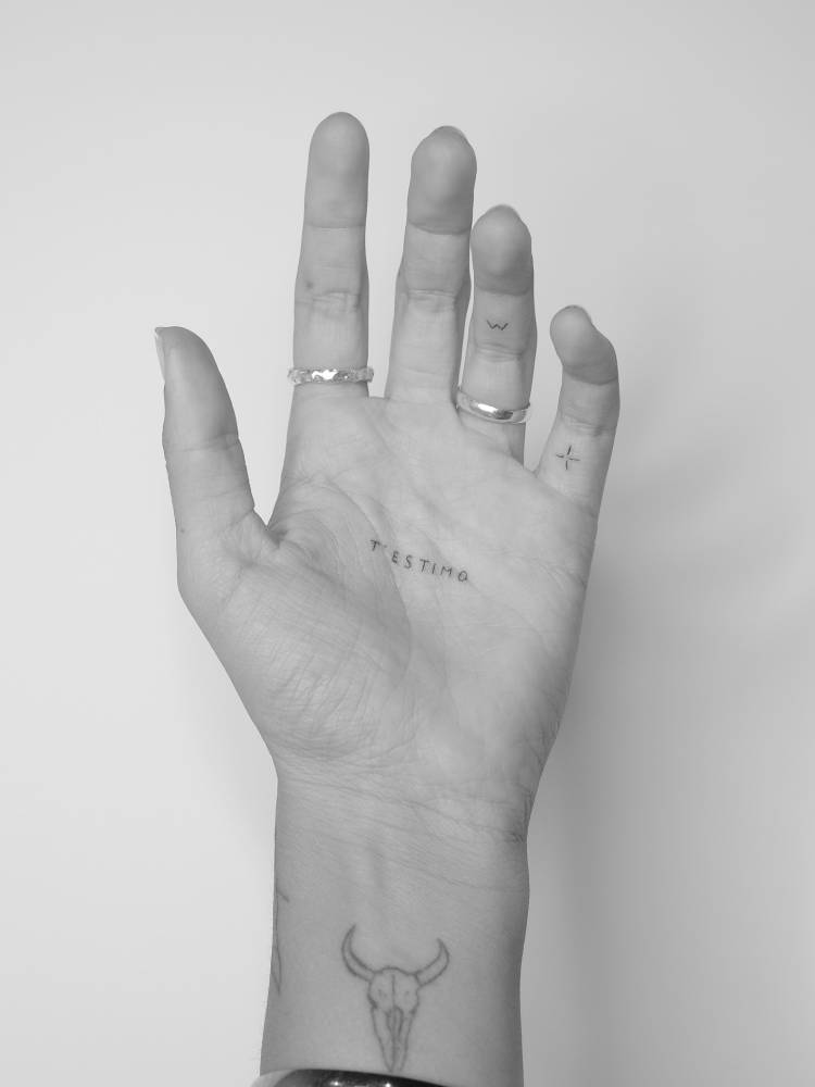 "T'estimo" lettering tattoo located on the palm.
