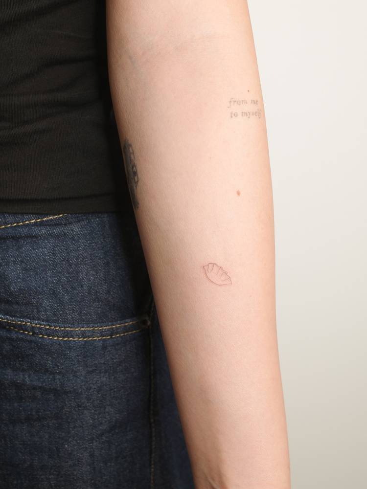 Tiny fine line style empanada tattoo located on the inner forearm.
