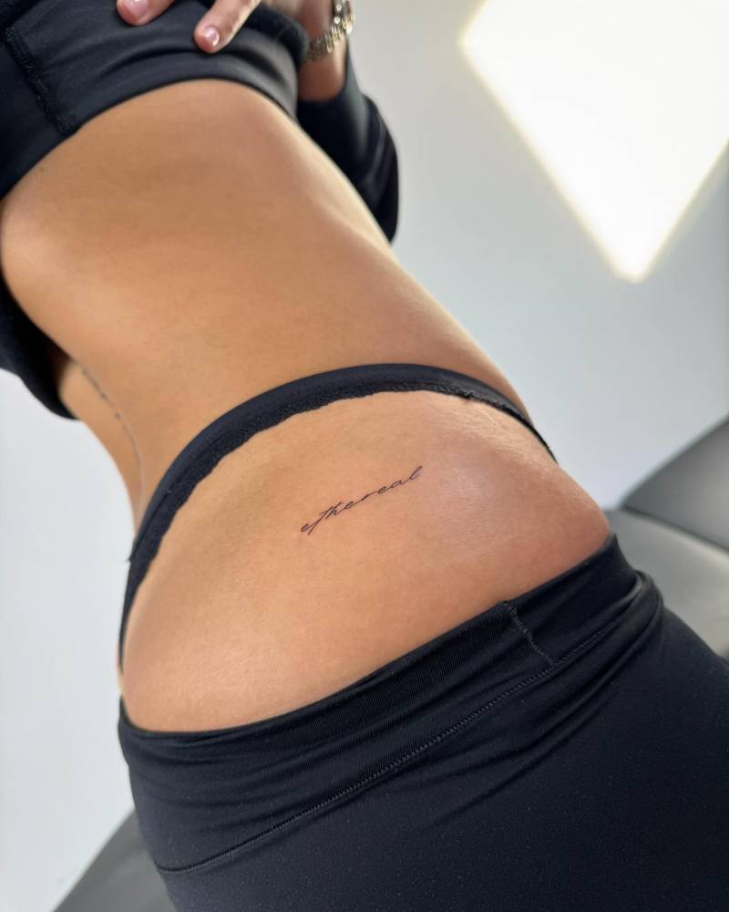 "Ethereal" lettering tattoo handwritten on the hip.