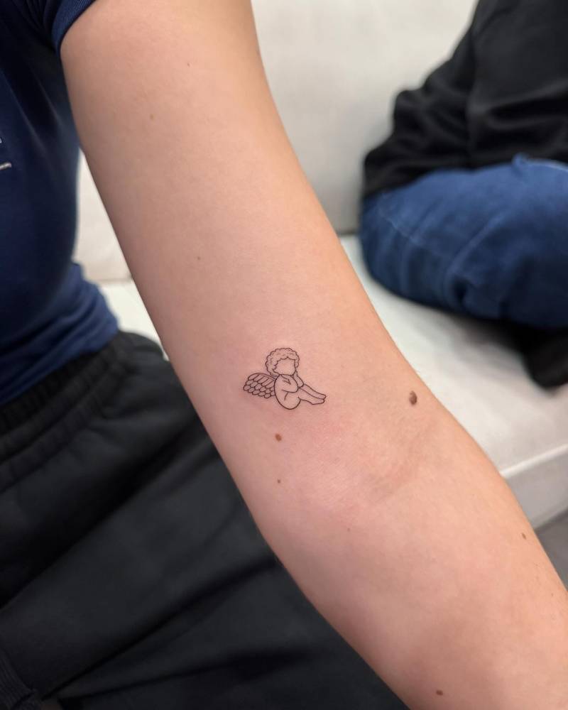 Little minimalistic cherub tattoo located on the inner arm.