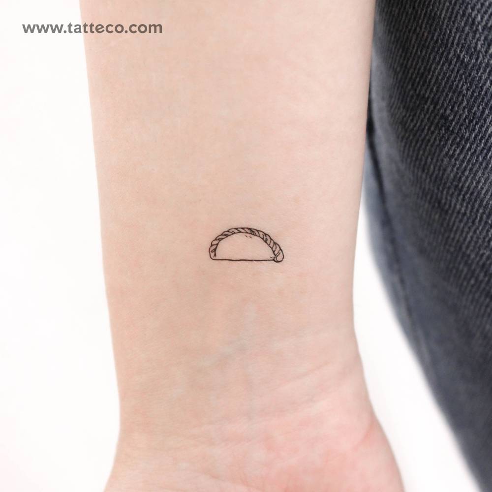 Tiny minimalistic empanadilla temporary tattoo located on the wrist.