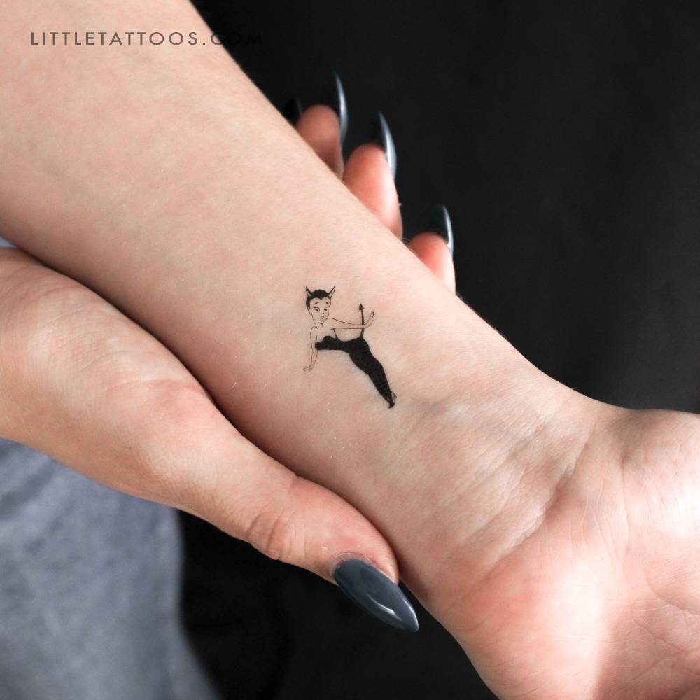 Cartoon style she-devil temporary tattoo located on the wrist.