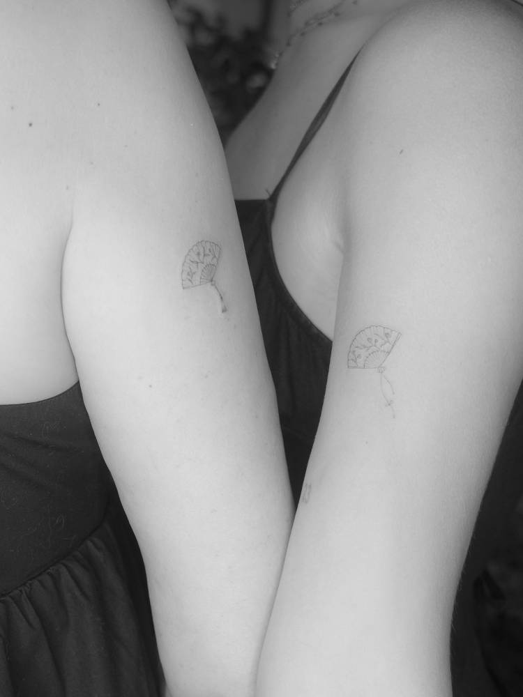 Matching fine line style hand fan tattoo for best friends.