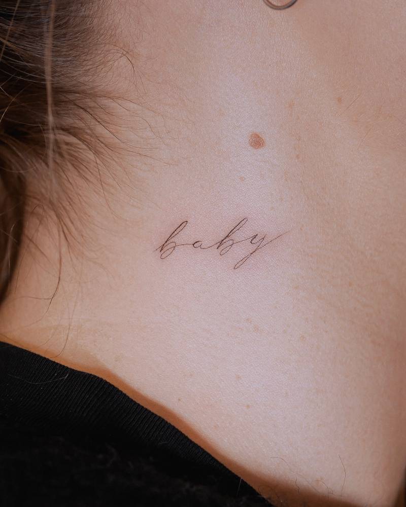 Word "baby" in script font tattooed on the neck.