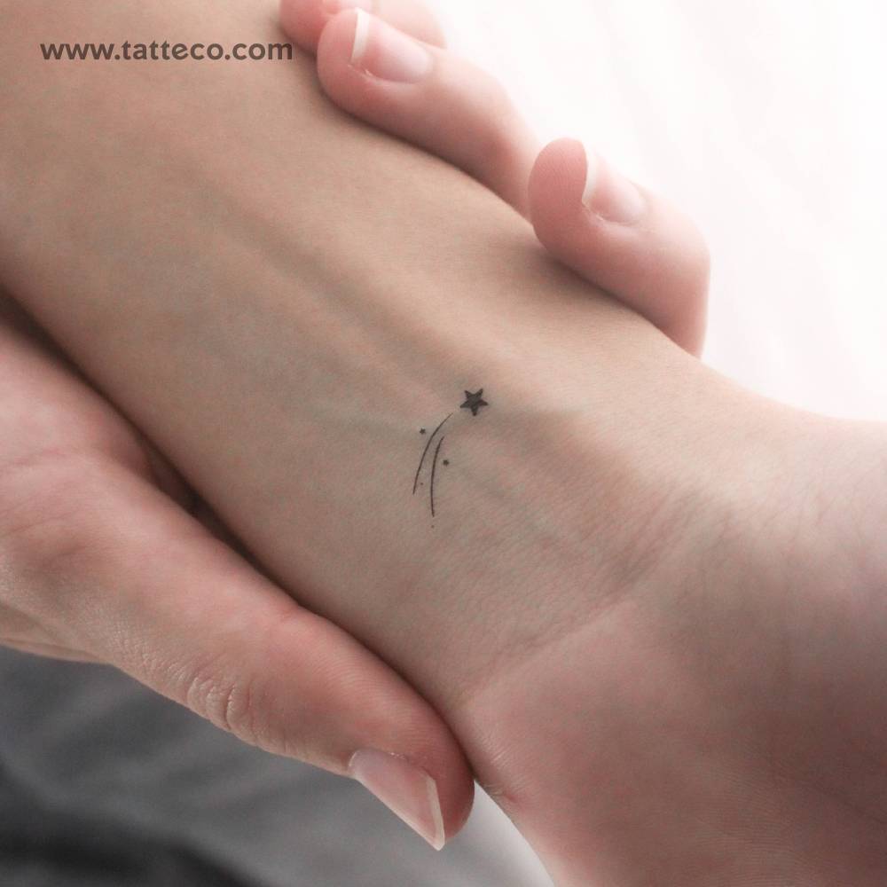 Small minimalistic shooting star temporary tattoo located on the wrist.