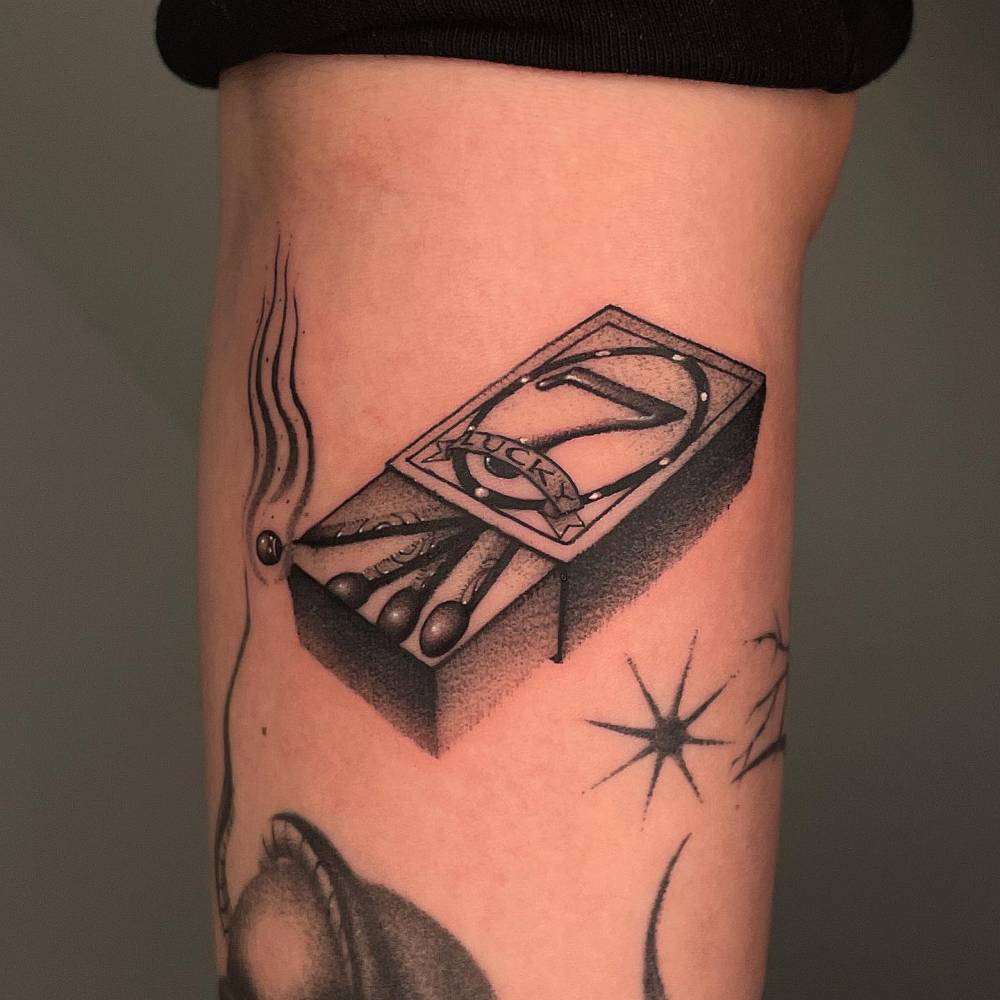 Dotwork style matchsticks tattoo located on the forearm.