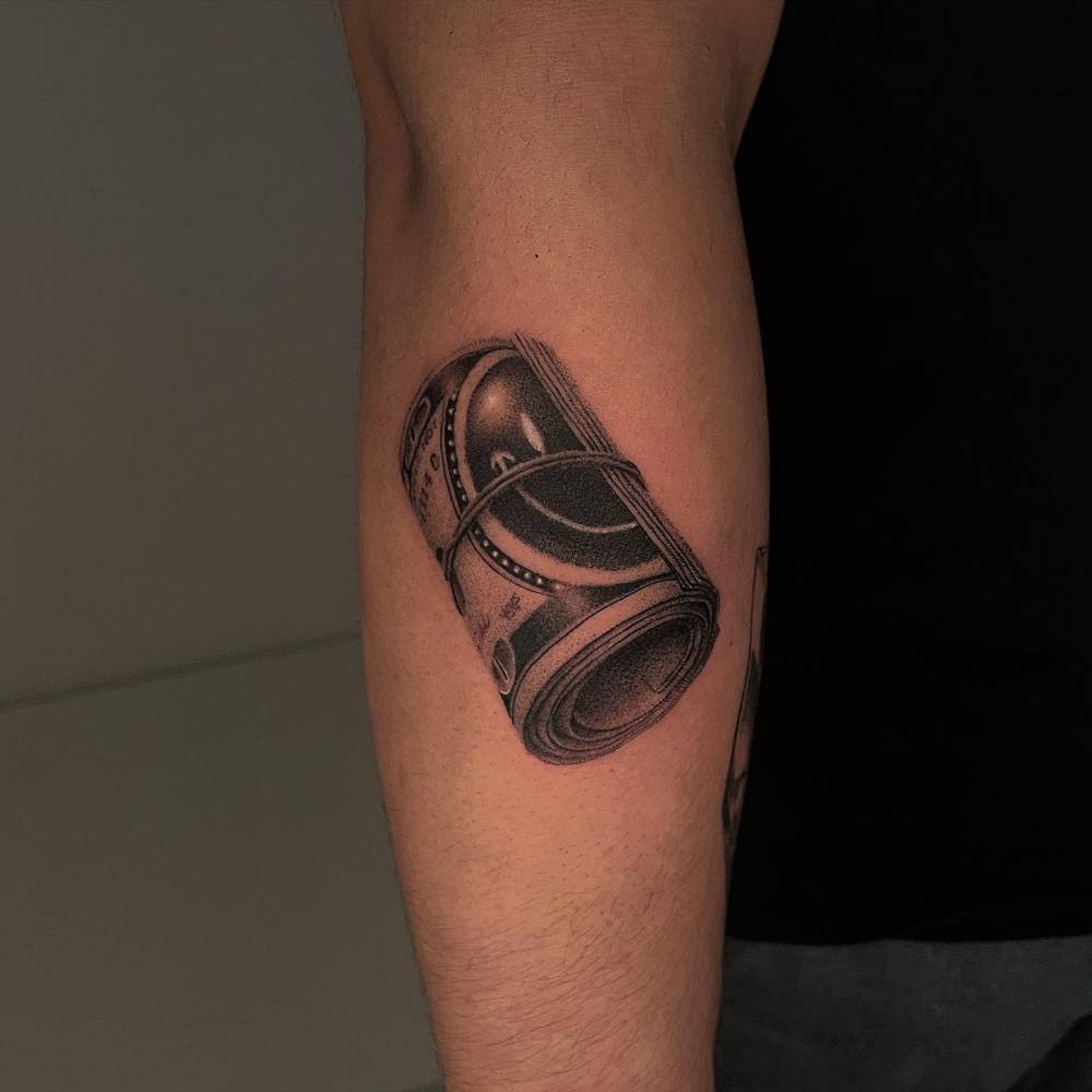 Smiley money tattoo located on the forearm, blackwork style.