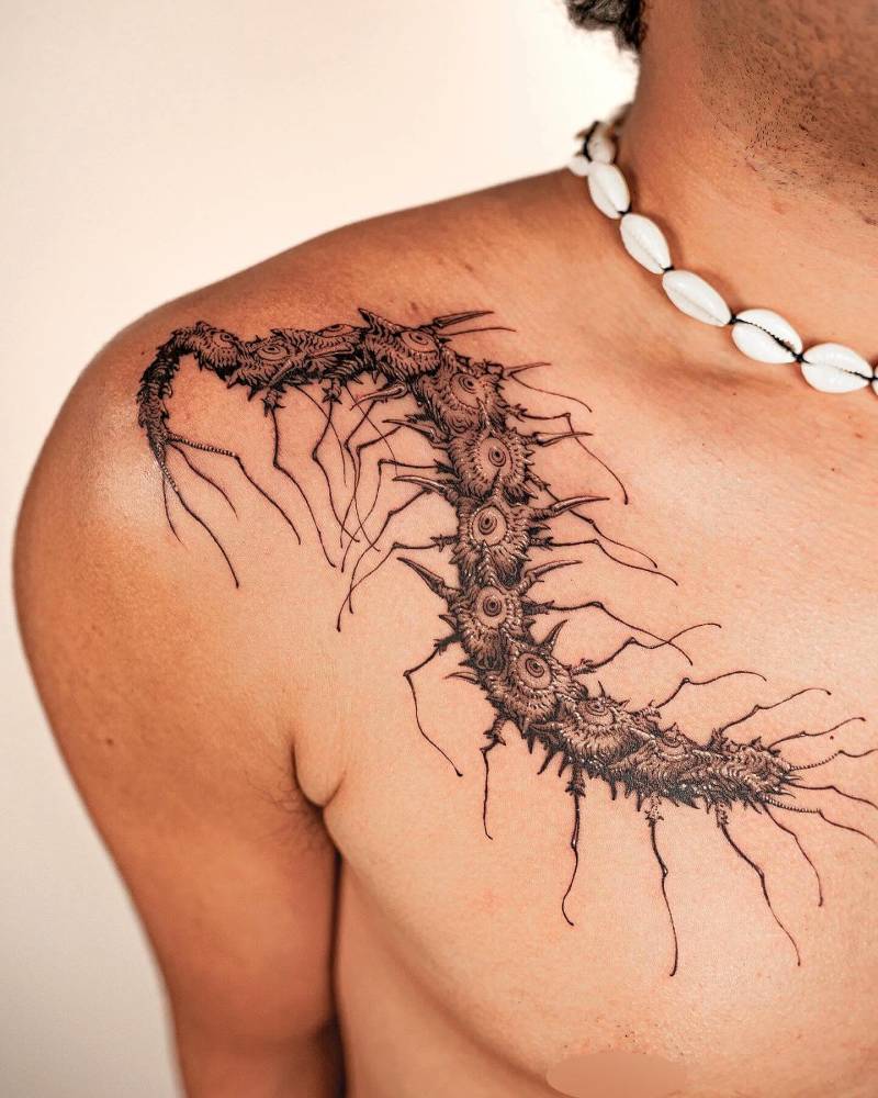 Centipede tattoo located on the shoulder and chest, done in illustrative style.