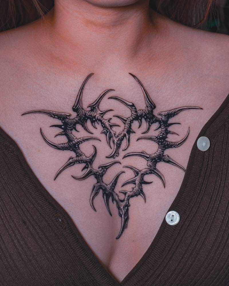 Thorns heart tattoo in illustrative style located on the chest.