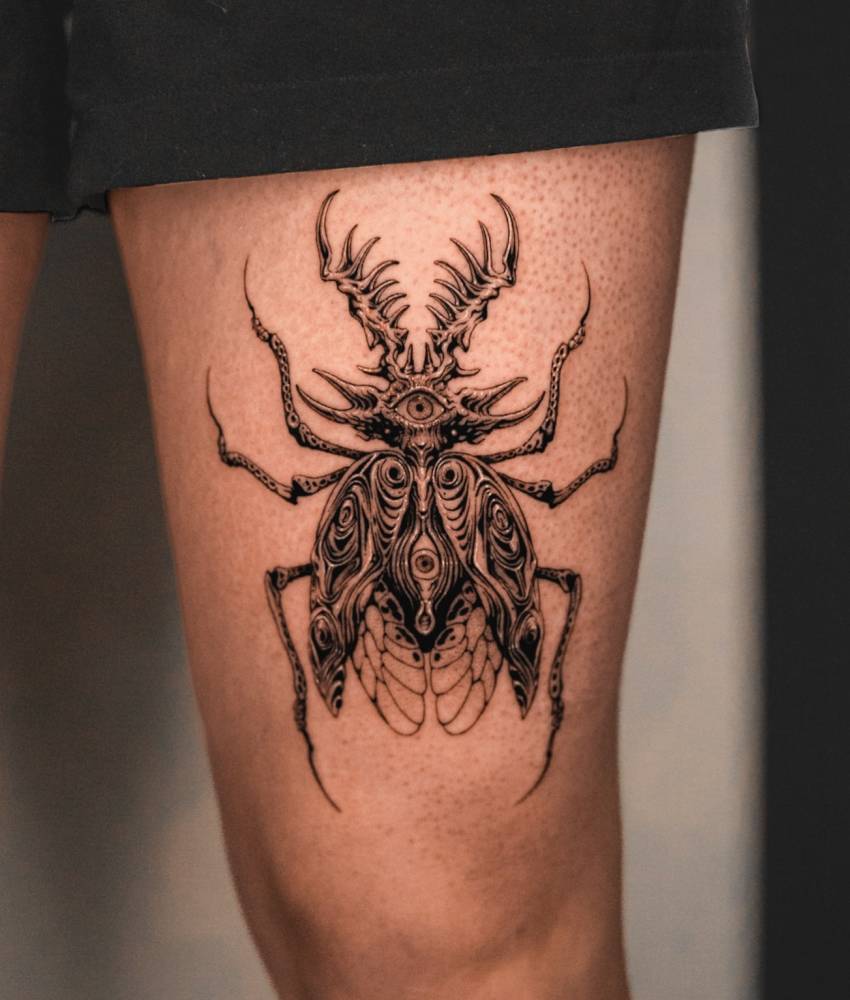 Beetle tattoo in blackwork style located on the thigh.