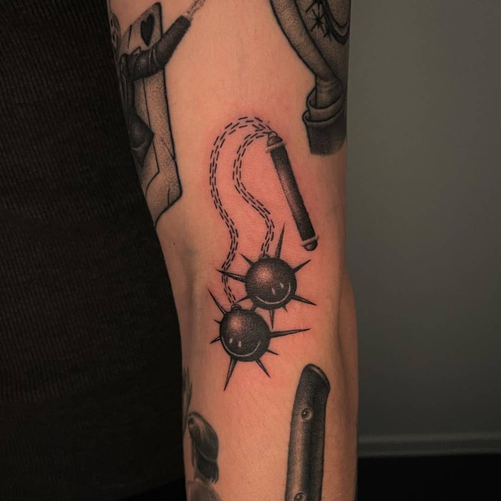 Smiley flail gap filler tattoo located on the elbow.