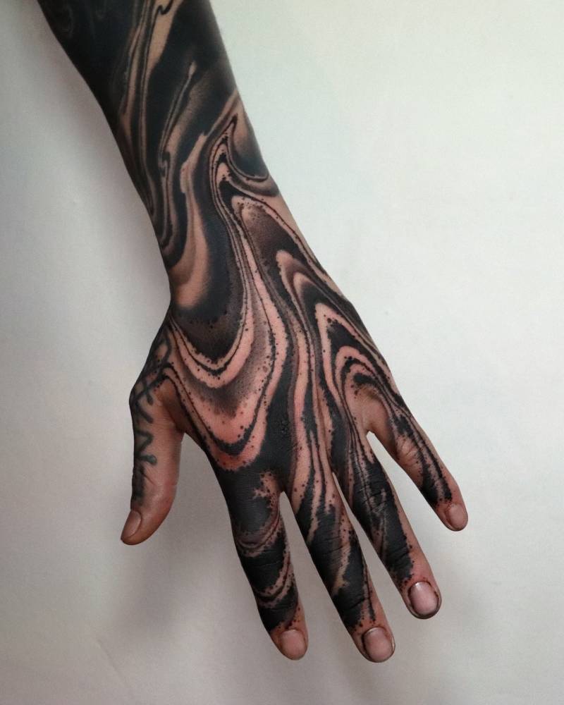 Abstract style tattoo located on the hand.