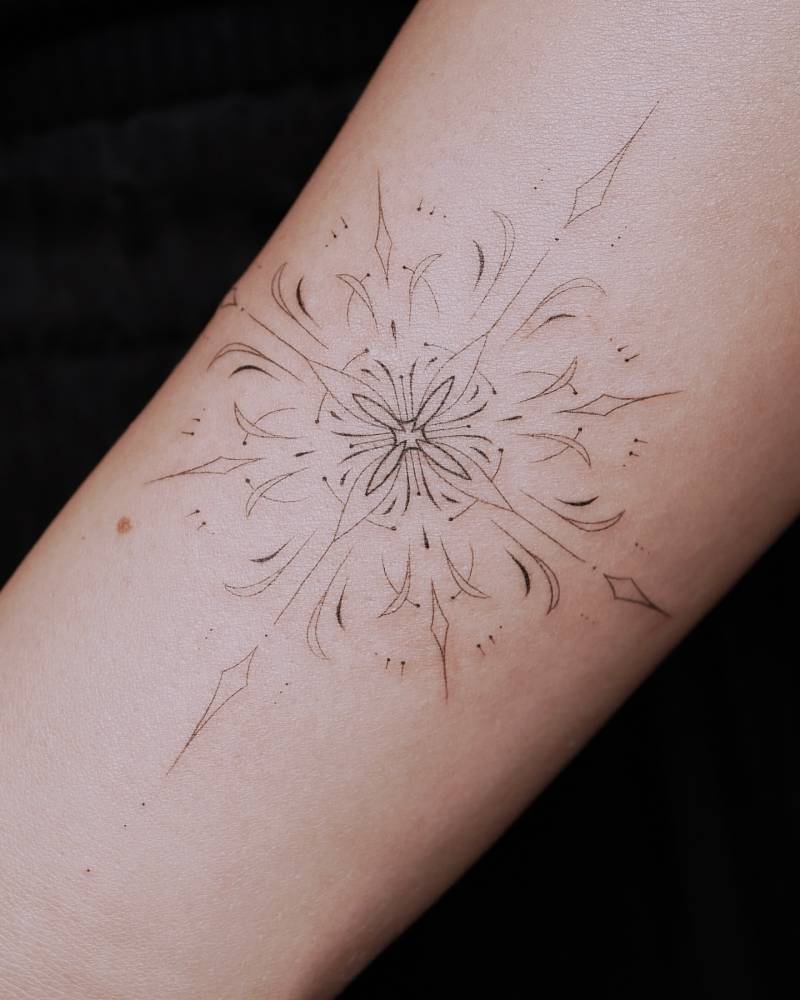 Fine line style ornamental design tattooed on the wrist.