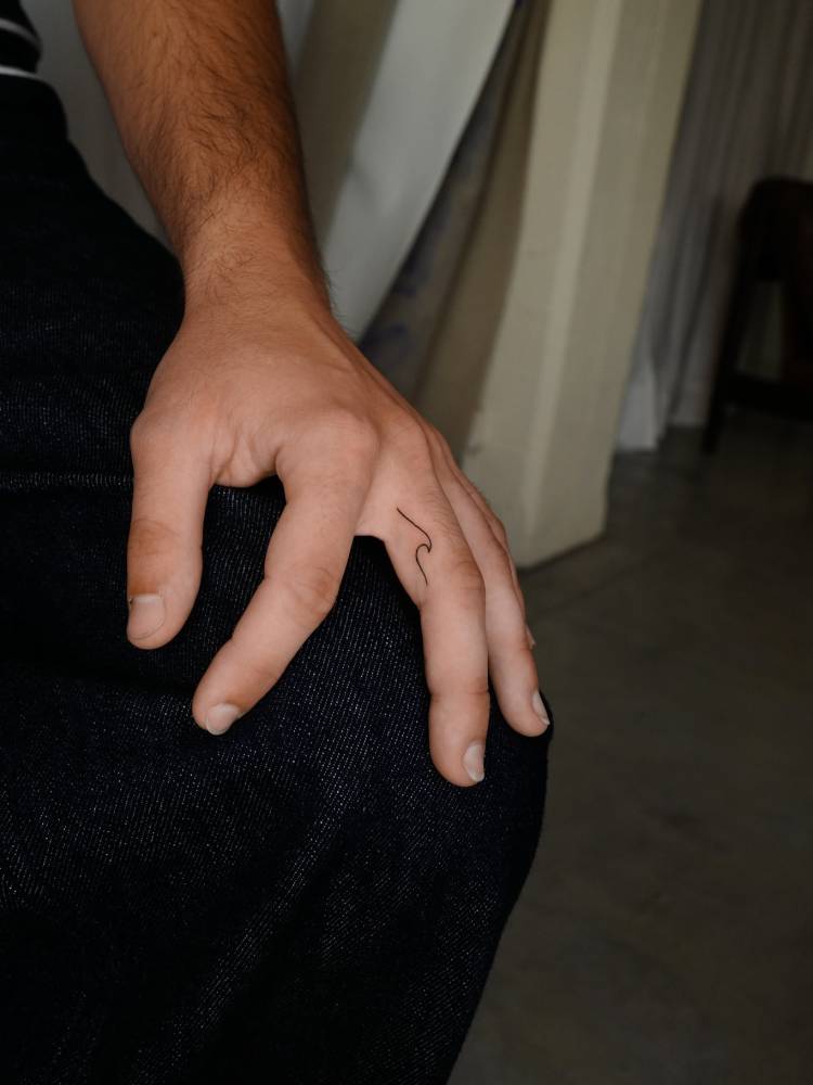 Minimalistic wave tattoo located on the finger.