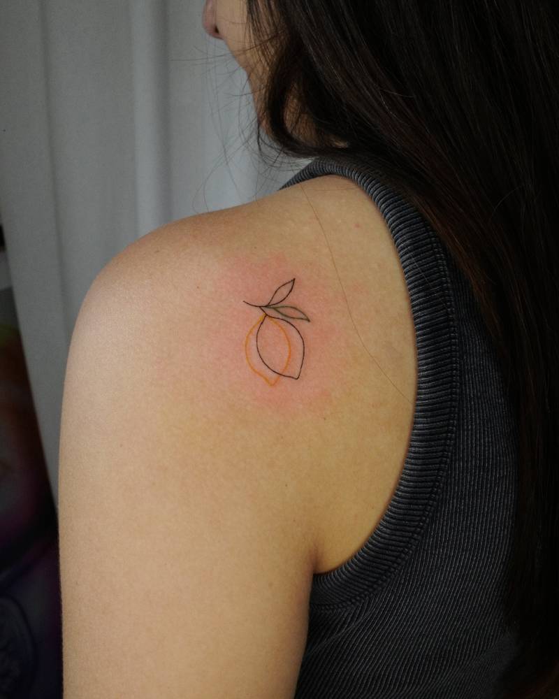 Fine line style lemons tattoo placed on the shoulder blade.