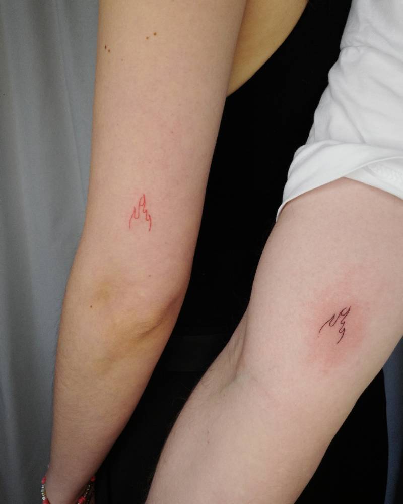Matching minimalistic fire tattoo for couple.