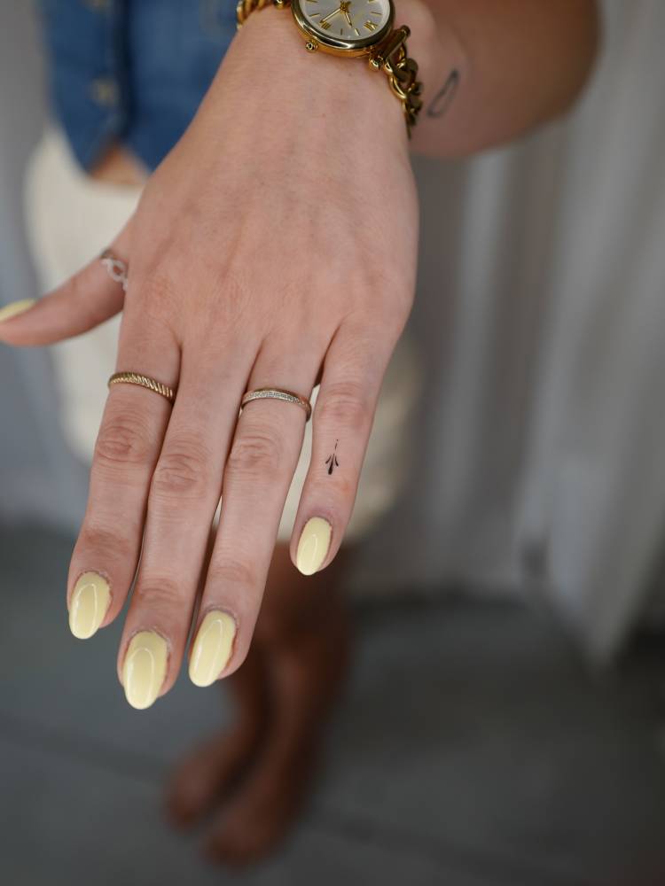 Tiny minimalistic ornament tattoo placed on the finger.