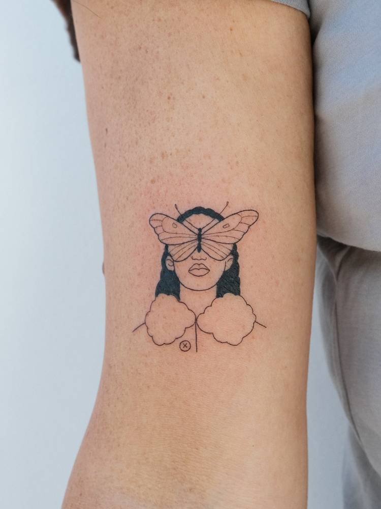 Butterfly woman portrait tattoo located on the bicep.