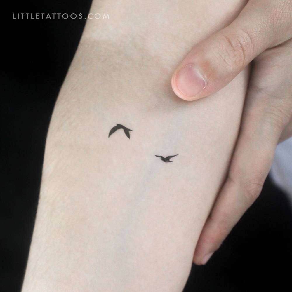 Two flying birds temporary tattoo located on the inner forearm.