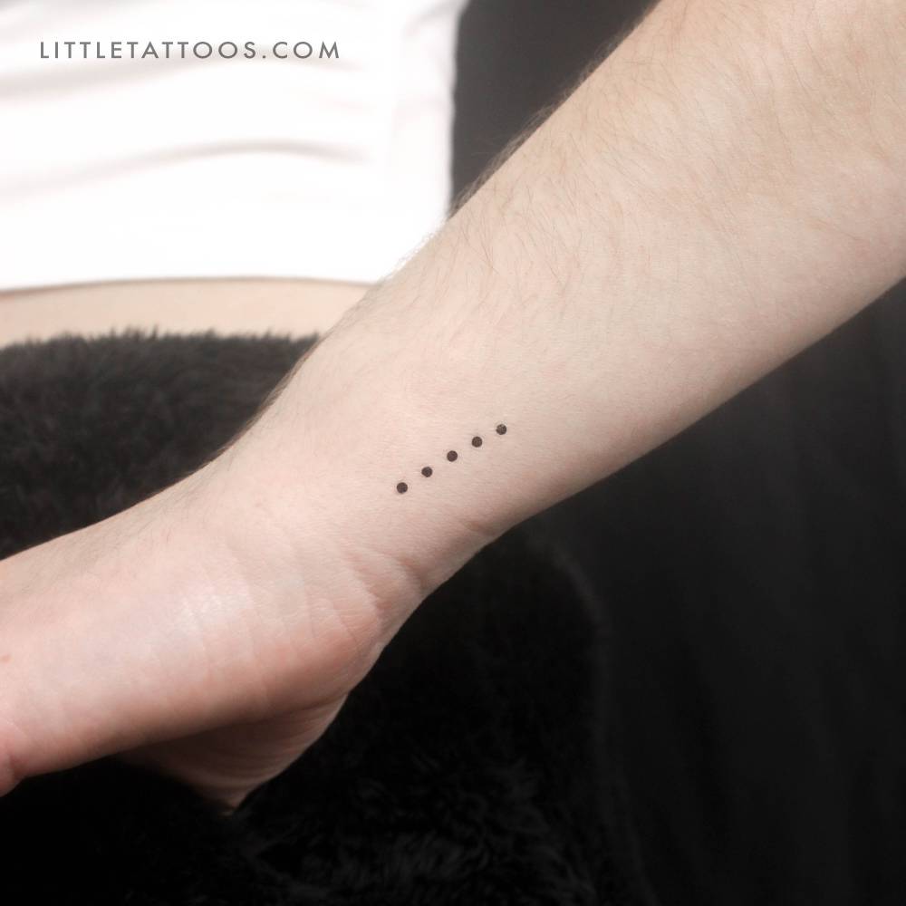 Five dots temporary tattoo in minimalistic style placed on the wrist.