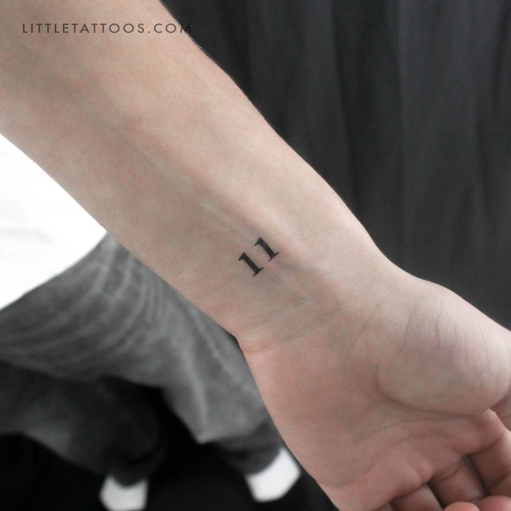 Serif font number "11" temporary tattoo located on the wrist.