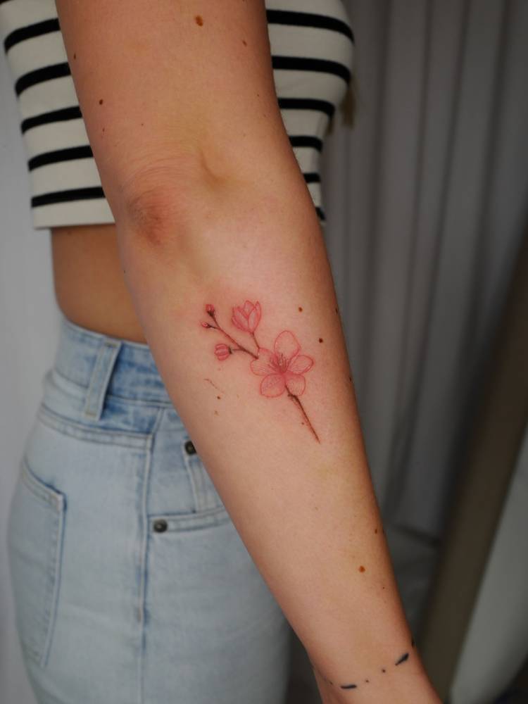 Cherry blossom tattoo in watercolor style done on the forearm.
