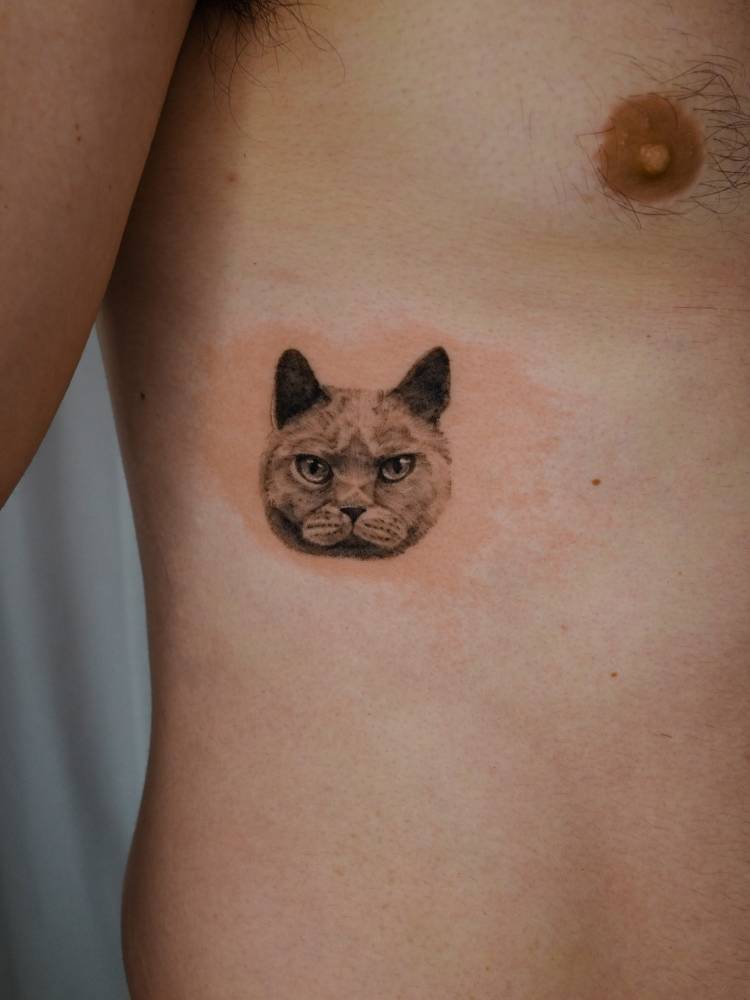 Micro-realistic style cat portrait tattoo located on the rib.