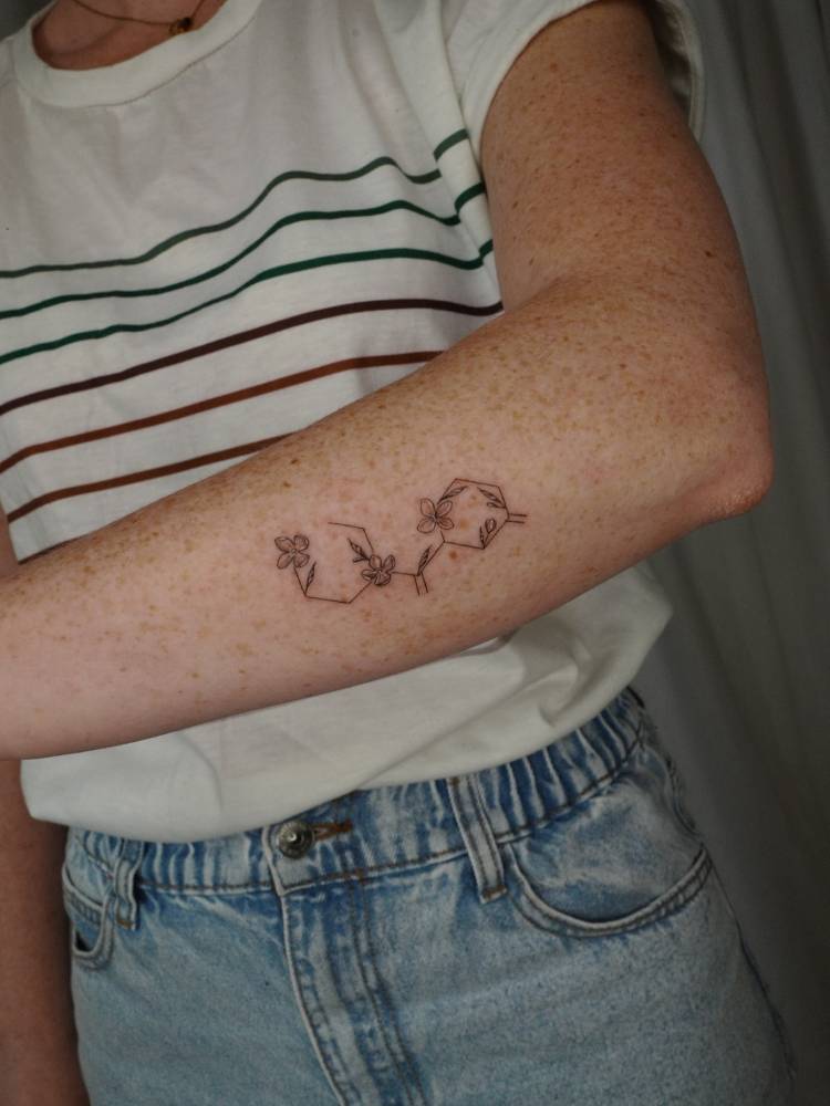Serotonin chemical structure tattooed on the forearm.