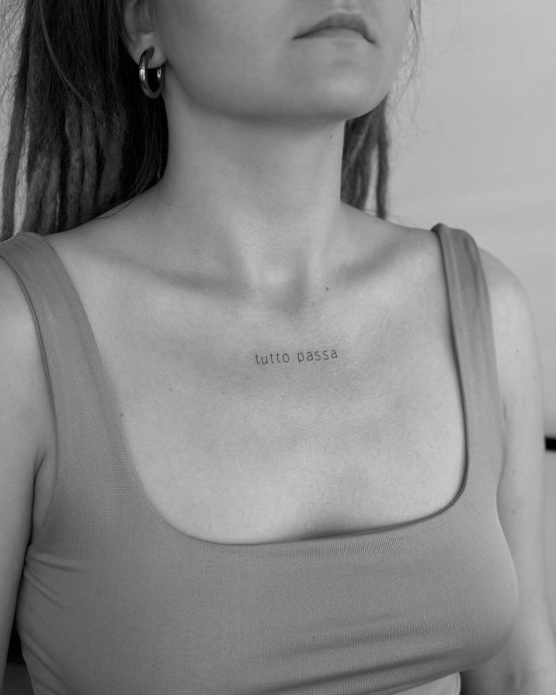 "Tutto passa" lettering tattoo located on the collarbone.