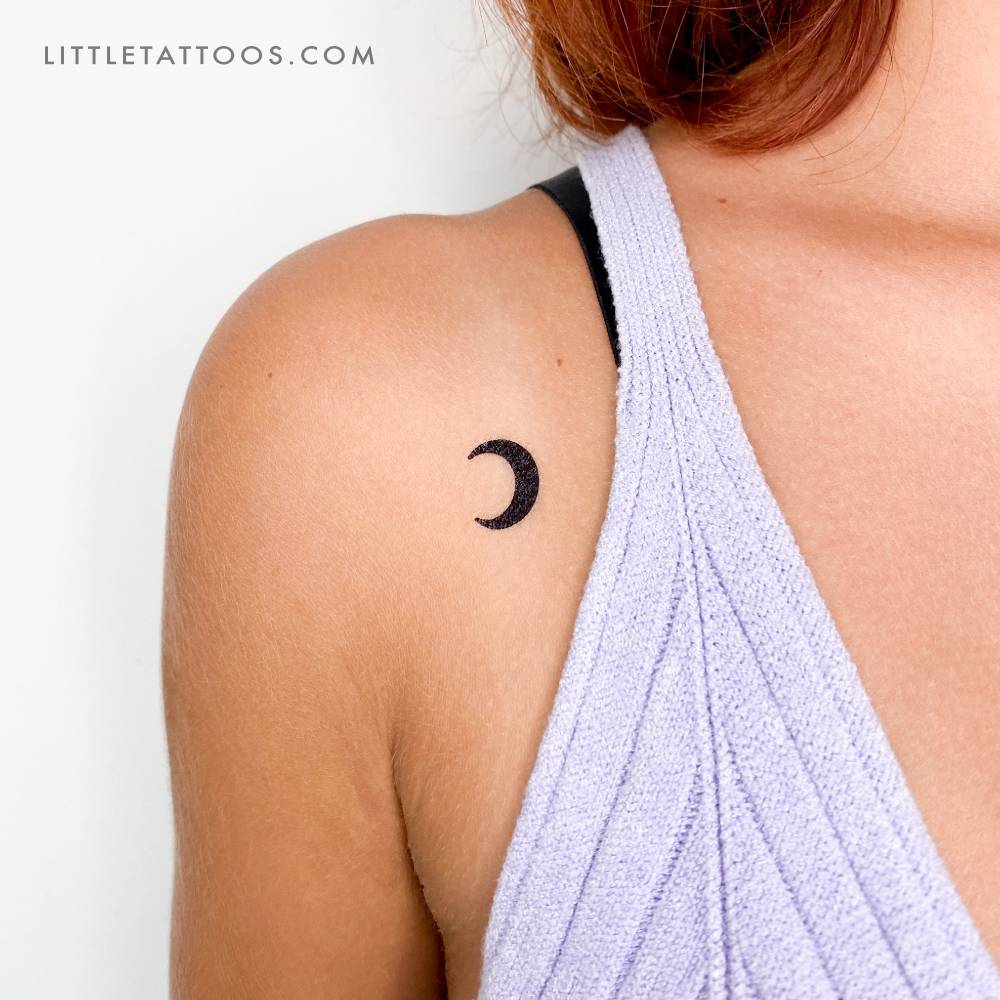 Black crescent moon temporary tattoo located on the shoulder.